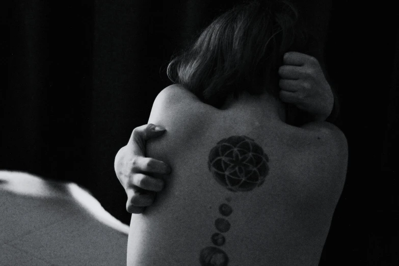 a woman with a tattoo on her back, by Adam Marczyński, pexels contest winner, flower of life, circles, monochromatic photo, chakras