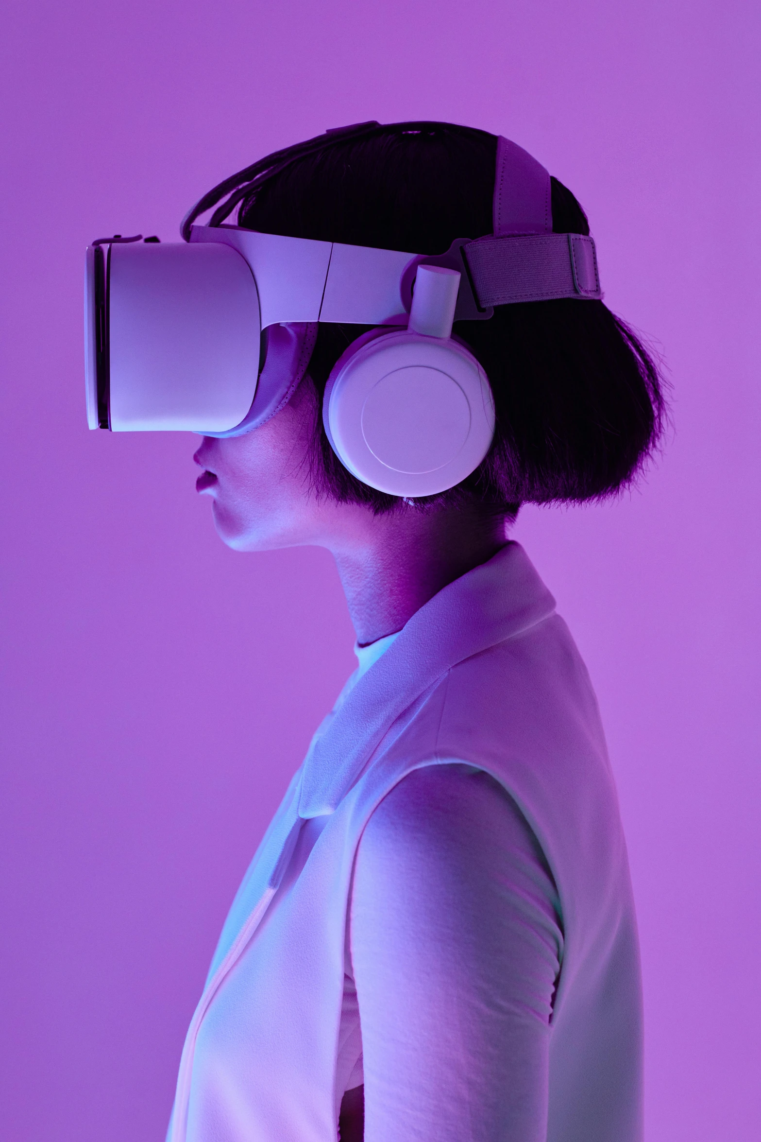 a woman wearing headphones in front of a purple background, inspired by Violet Oakley, afrofuturism, using a vr headset, facing away from camera, mit technology review, real photo