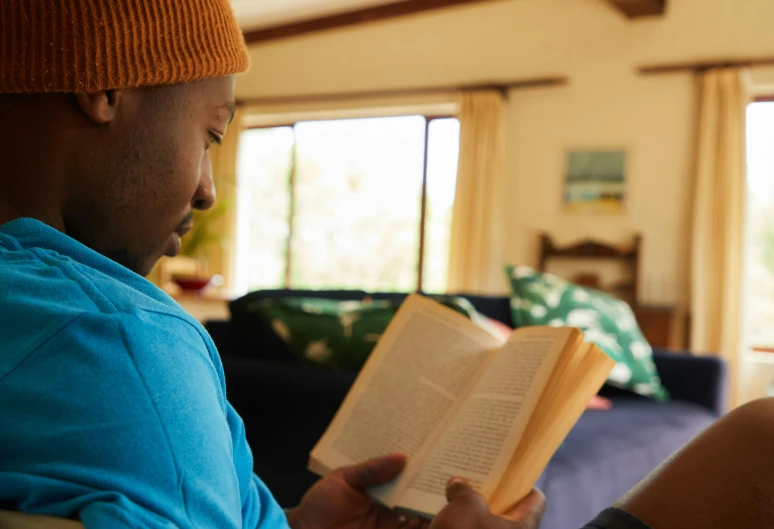 a man sitting in a chair reading a book, pexels contest winner, someone in home sits in bed, kano), vivid and balanced, sitting in rural living room