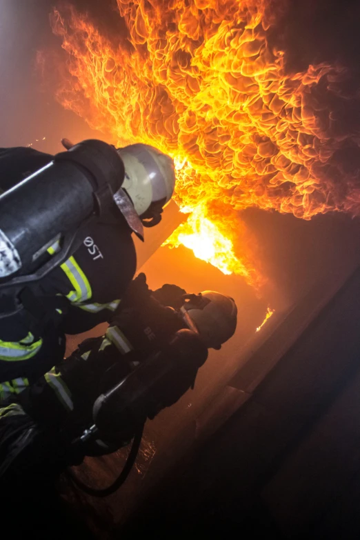 a firefighter using a hose to put out a fire, a picture, by Daniel Lieske, pexels contest winner, gopro footage, on ship, the great door of hell, panzer