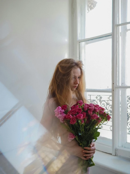 a woman standing in front of a window holding a bunch of flowers, pexels contest winner, romanticism, portrait of kim petras, bouguereau and bowater, leaving a room, queer woman