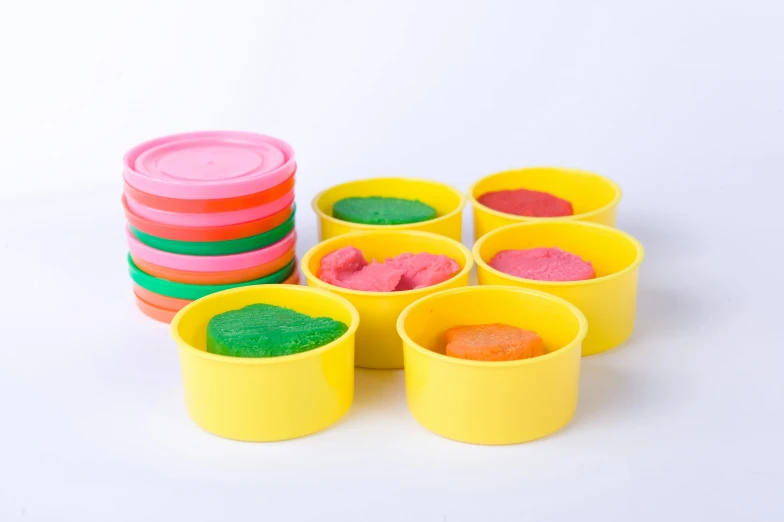 a group of plastic cups filled with colored sand, product image, soft pads, 8 x, yellow