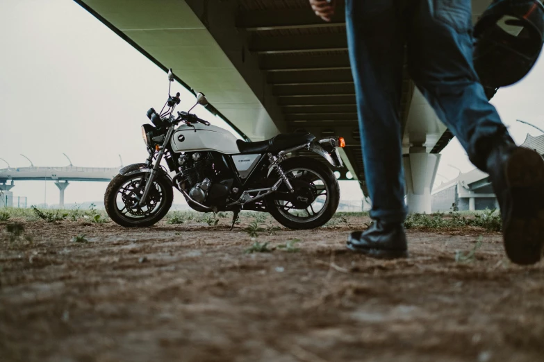 a person walking next to a motorcycle under a bridge, inspired by Hiroshi Honda, pexels contest winner, looking at the ground, profile image, thumbnail, classic portrait