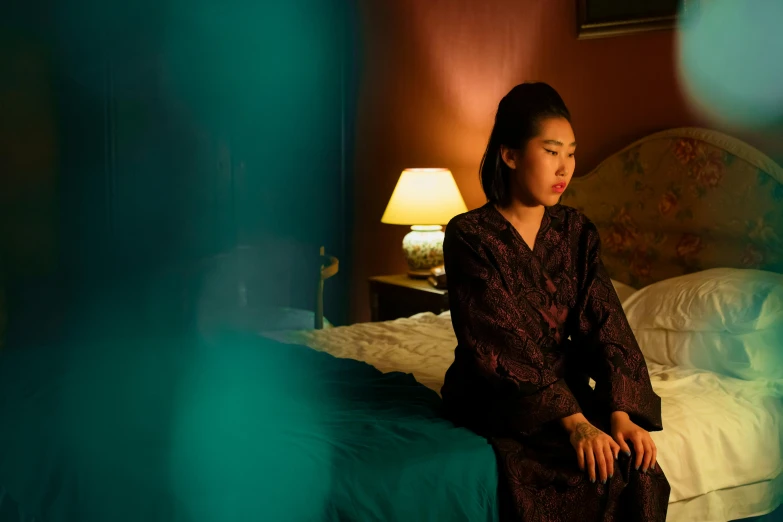a woman sitting on a bed in a room, inspired by Elsa Bleda, pexels contest winner, 8 0 s asian neon movie still, film noir, traditional chinese clothing, ambient teal light
