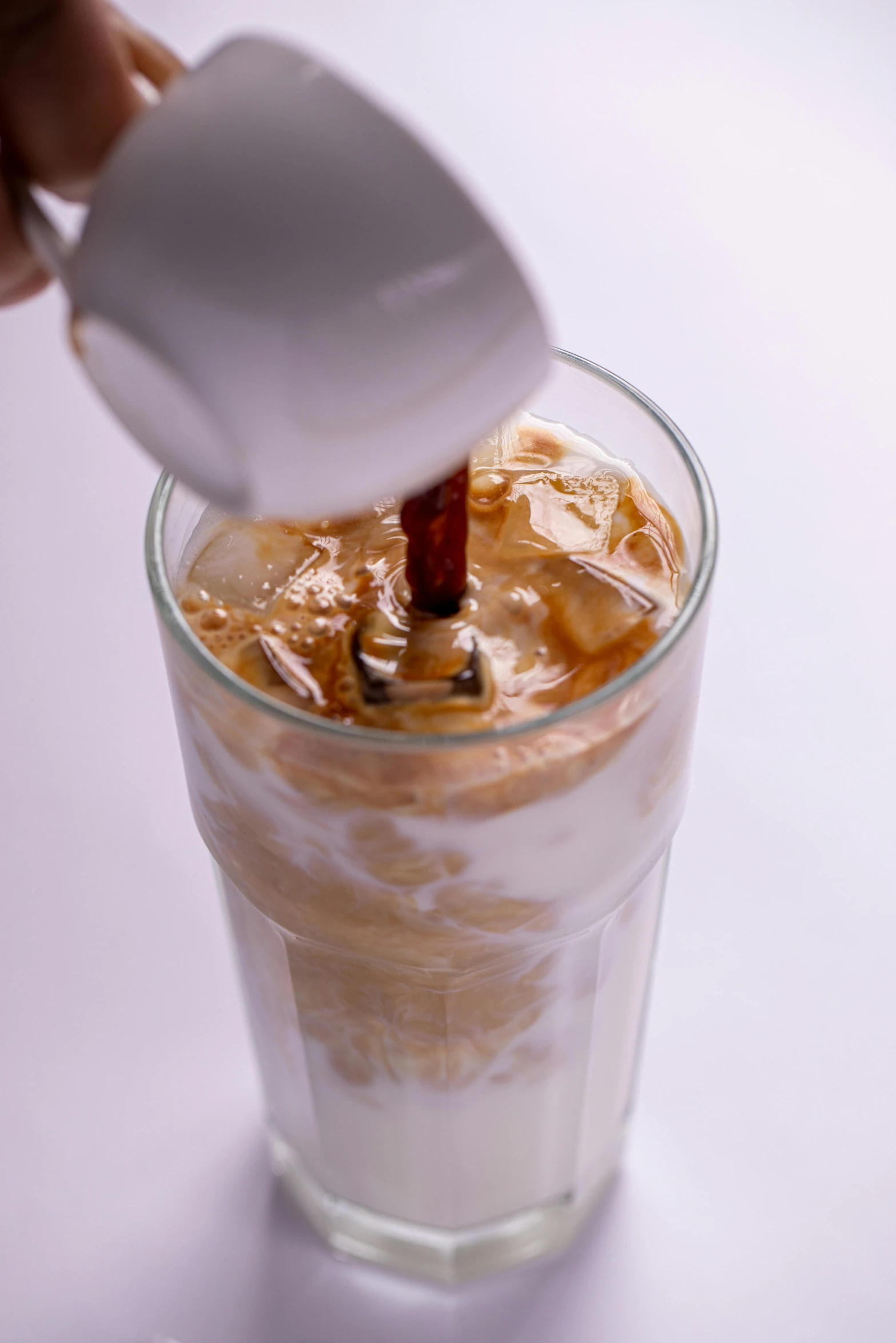 a person pouring a drink into a glass, iced latte, daopao, thumbnail, extremely close shot