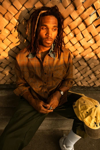 a man with dreadlocks sitting on some steps, an album cover, inspired by Richard Wright, trending on pexels, golden glow, wearing a linen shirt, backlit glow, ashteroth