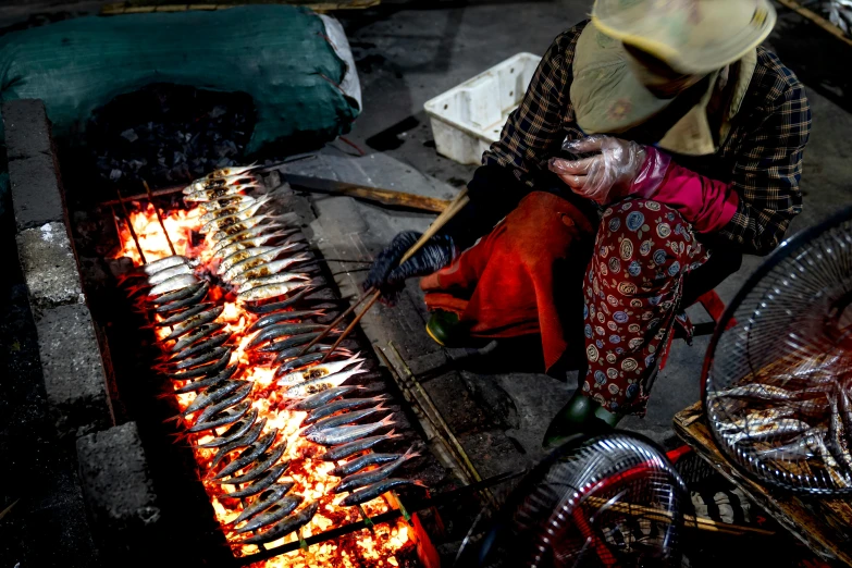 a woman is cooking fish on a grill, by Meredith Dillman, pexels contest winner, hurufiyya, sichuan, avatar image, blacksmith, rectangle