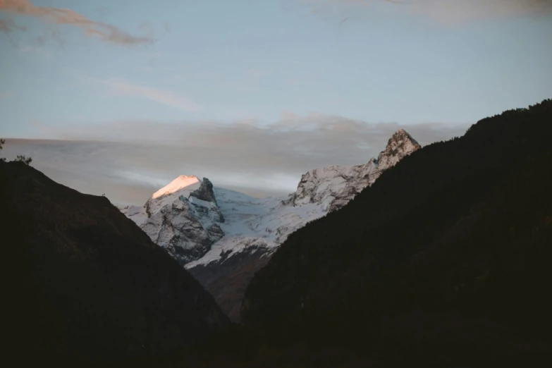a mountain with a snow covered peak in the distance, by Daniel Seghers, unsplash contest winner, soft evening lighting, fan favorite, switzerland, low quality footage
