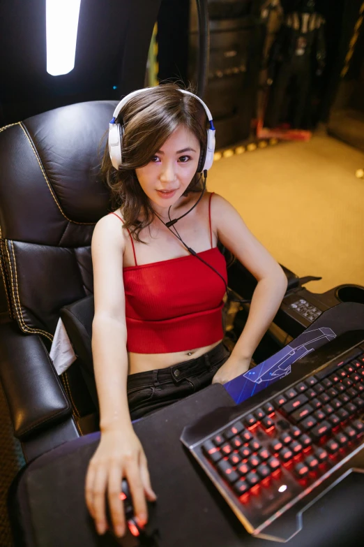 a woman sitting in a chair with a keyboard and headphones, inspired by Lan Ying, featured on reddit, instagram model, led gaming, asia, roleplay