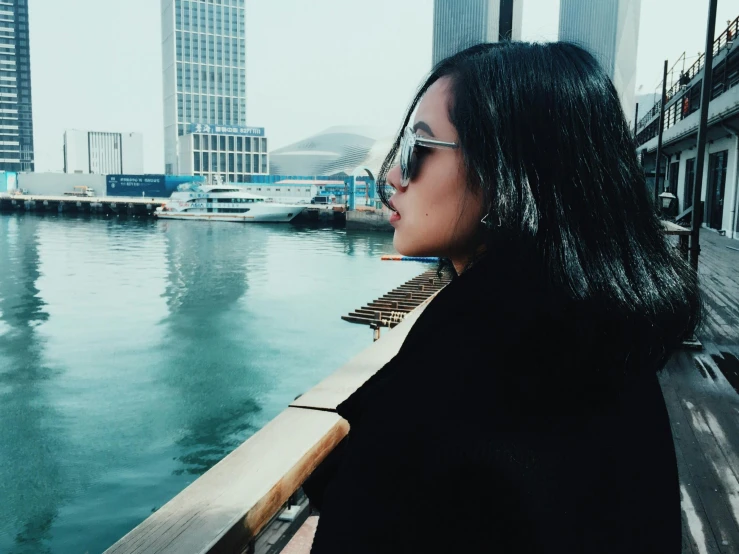 a woman looking out over a body of water, pexels contest winner, hurufiyya, wearing versace sunglasses, a young asian woman, harbour, profile image