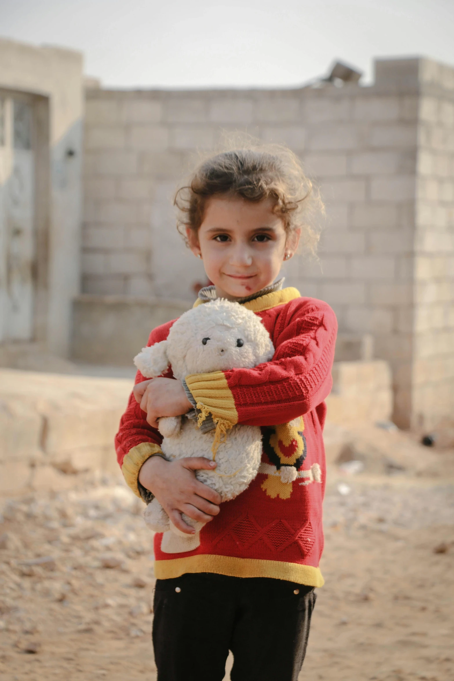 a little girl that is holding a teddy bear, by Maryam Hashemi, hurufiyya, on a village, cotton, multicoloured, damaged