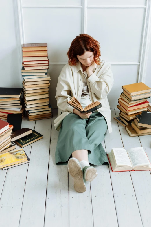 a woman sitting on the floor reading a book, trending on pexels, renaissance, piles of books, ( redhead, school curriculum expert, wide full body