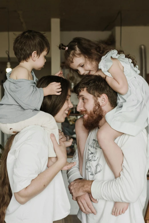 a family poses for a picture in front of a christmas tree, inspired by The Family Circus, pexels contest winner, renaissance, curled beard, hugging each other, australian, 2 years old