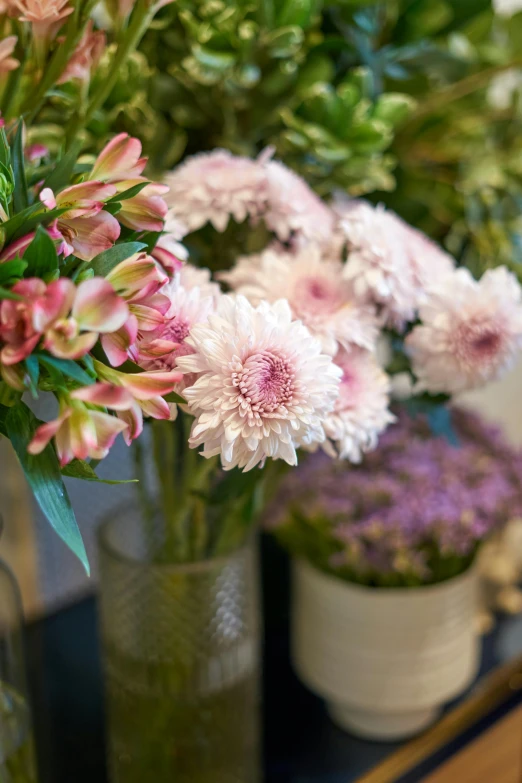 a table topped with vases filled with flowers, pink flowers, close ups, commercially ready, chrysanthemum