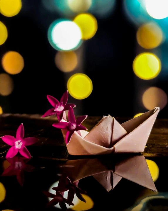 a paper boat sitting on top of a table, a still life, by Julia Pishtar, unsplash, reflective orchid flower, starlit, thumbnail, portrait mode photo