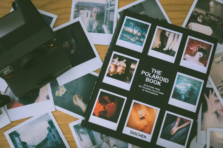 a polaroid book sitting on top of a wooden table, by Julia Pishtar, unsplash, various items, brandon woelfel, contact sheet, 2 0 0 0's photo