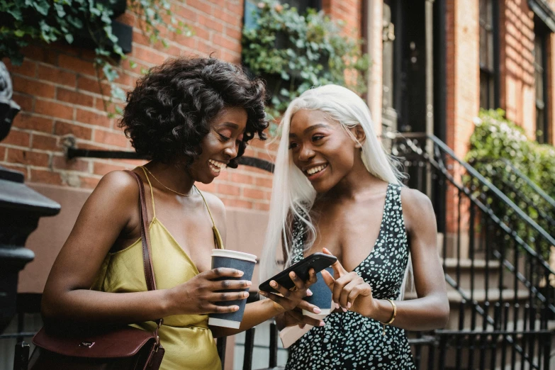 a couple of women standing next to each other on a street, trending on pexels, happening, black girl, android phones, avatar image