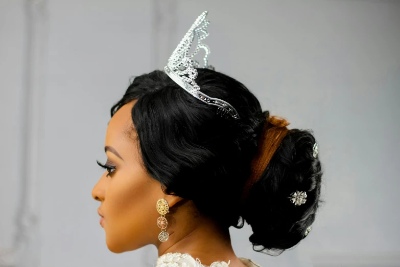 a woman with a tiara on top of her head, by Chinwe Chukwuogo-Roy, close-up shot taken from behind, silver，ivory, small crown, tiara