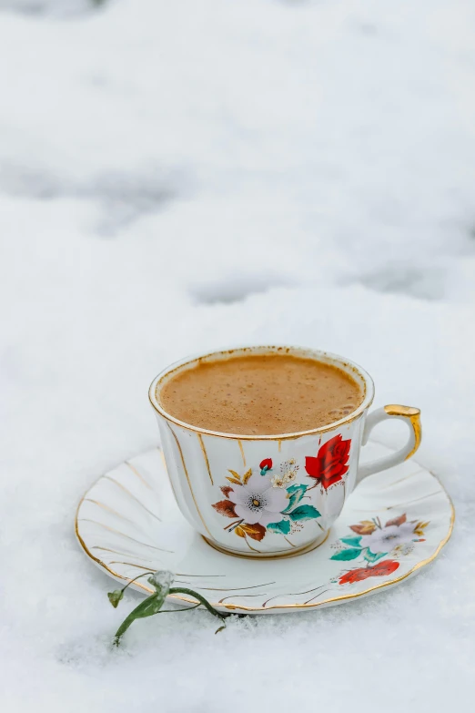 a cup of coffee on a saucer in the snow, a colorized photo, by Julia Pishtar, hurufiyya, alessio albi, thumbnail, turkey, brown