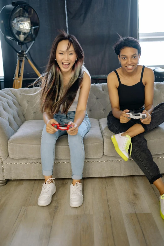 two women sitting on a couch playing video games, inspired by Wang Duo, featured on reddit, hollywood promotional image, diverse outfits, youtuber, profile image