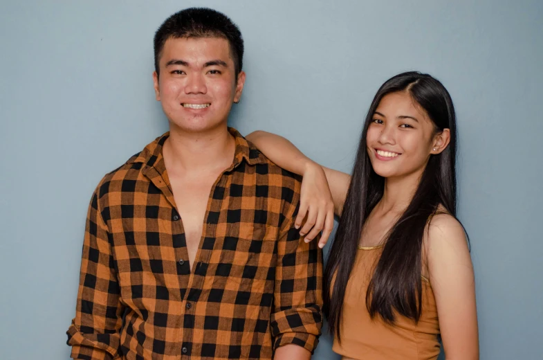 a man and a woman standing next to each other, by Robbie Trevino, both smiling for the camera, studio photo, background image, asian human