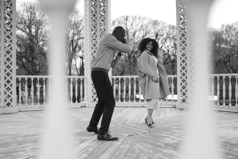 a black and white photo of a man and a woman dancing, by Lily Delissa Joseph, pexels contest winner, visual art, in a city park, at a fashion shoot, behind the scenes photo, video footage