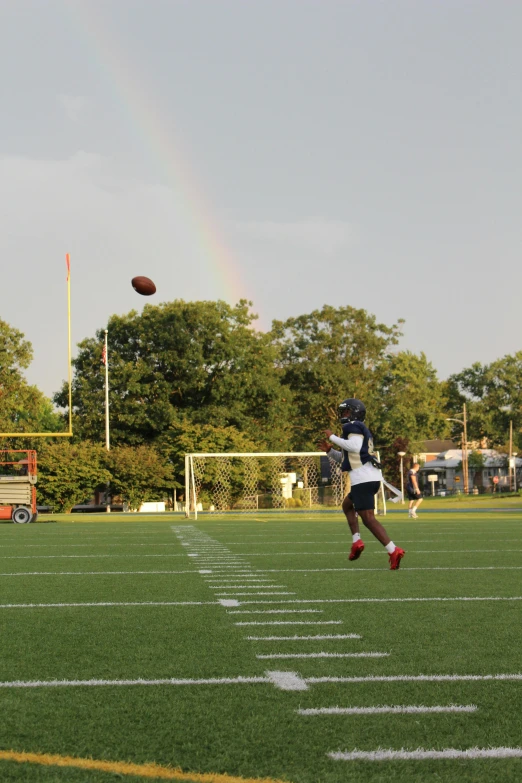 a group of young men playing a game of football, by Joe Stefanelli, unsplash, rainbows in the background, in louisiana, panorama shot, b - roll