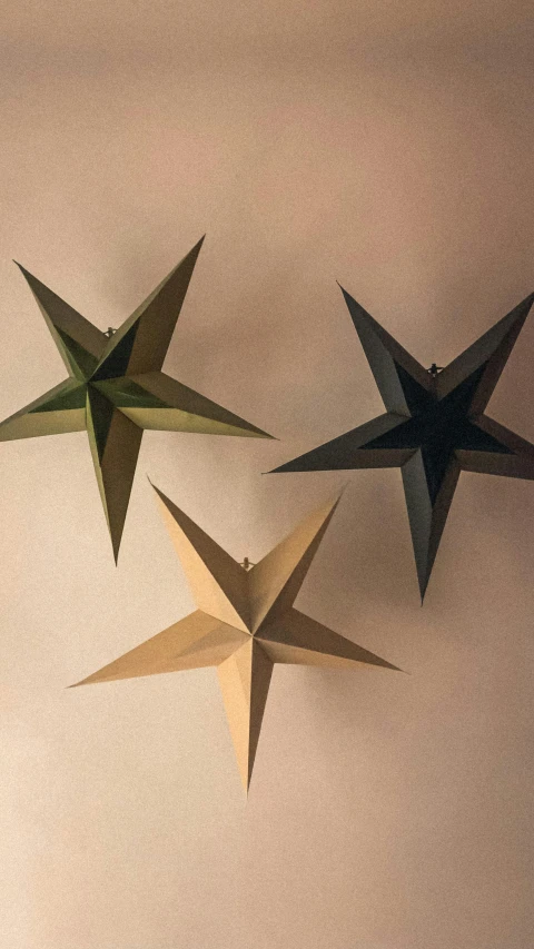 three origami stars hanging on a wall, by Felicity Charlton, stark lighting, high angle, muted green, navy