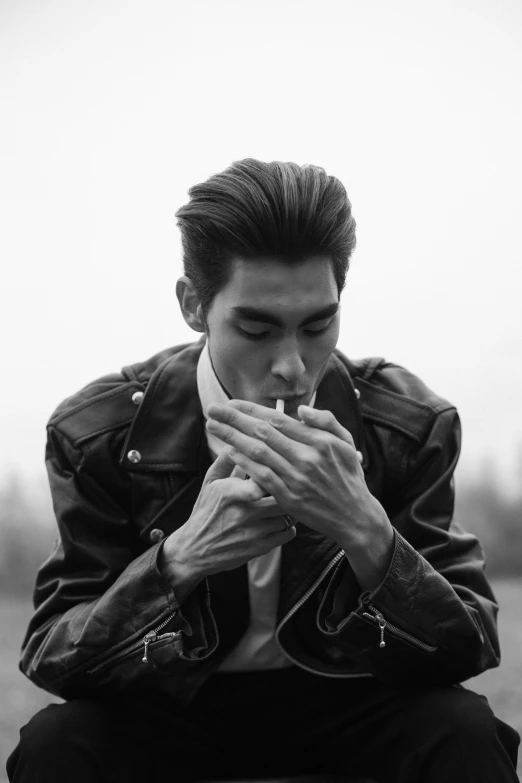 a man in a leather jacket smoking a cigarette, a black and white photo, inspired by Zhang Han, tumblr, rockabilly hair, 5 0 s aesthetic, square masculine jaw, lowres