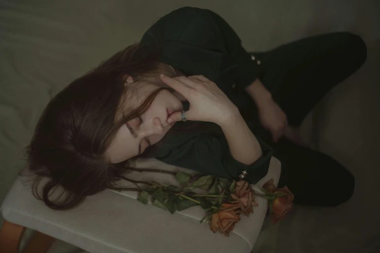 a woman laying on top of a chair next to a flower, inspired by Elsa Bleda, pexels contest winner, romanticism, tired face, roses, low quality footage, girl with brown hair