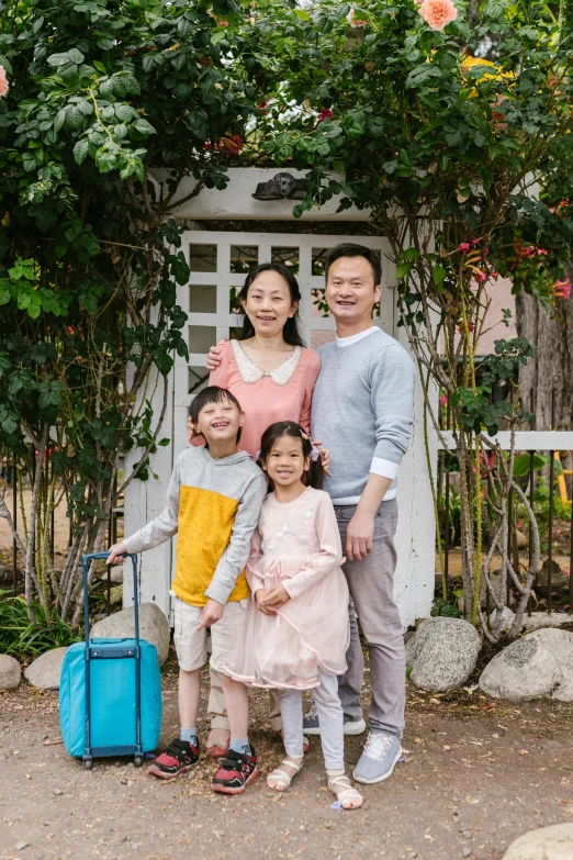 a family posing for a picture in front of a house, inspired by Cui Bai, pexels contest winner, happening, luggage, portrait full body, taejune kim, in garden