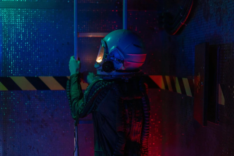 a person standing in a room with a helmet on, cyberpunk art, inspired by Elsa Bleda, pexels contest winner, holography, in flight suit, sci-fi night club, vecna from stranger things, behind the scenes photo