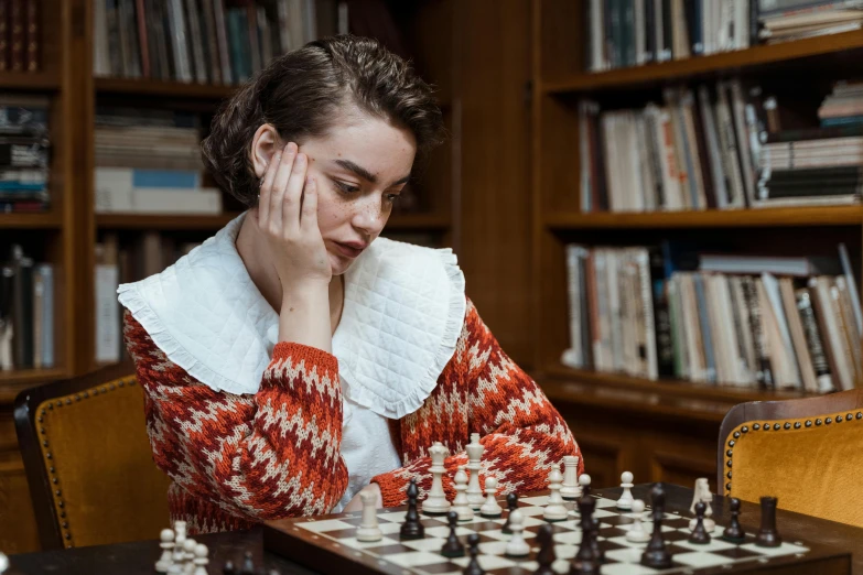 a woman sitting at a table playing a game of chess, a portrait, unsplash, librarian, dressed like in the 1940s, samara weaving, thumbnail