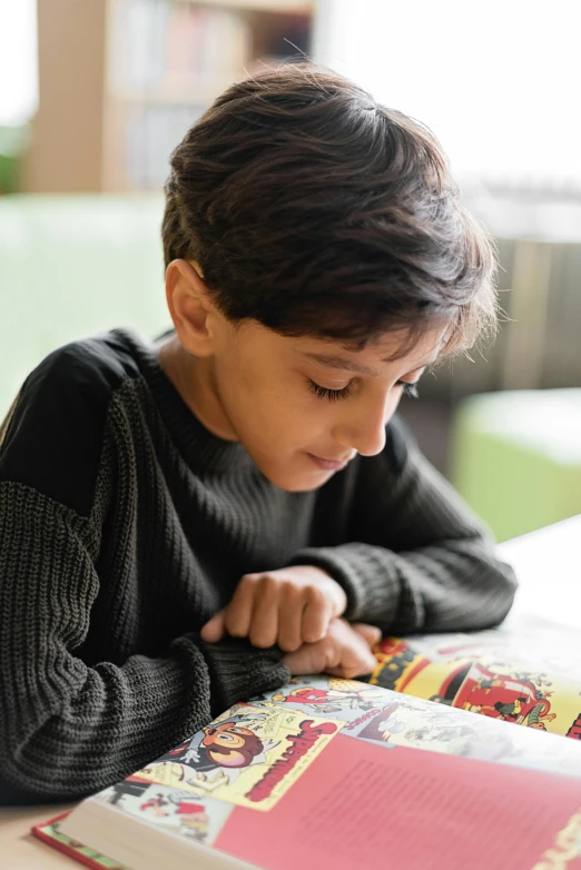 a young boy sitting at a table reading a book, pexels contest winner, qajar art, school curriculum expert, dynamic closeup, middle eastern, 15081959 21121991 01012000 4k