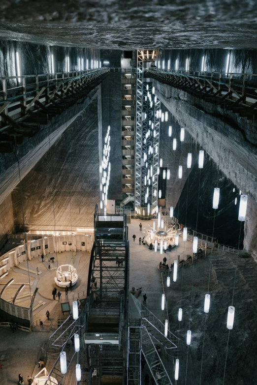 a large room filled with lots of lights, inspired by René Burri, unsplash contest winner, kinetic art, in dusty open pit mine, elegant walkways between towers, high - angle view, grey