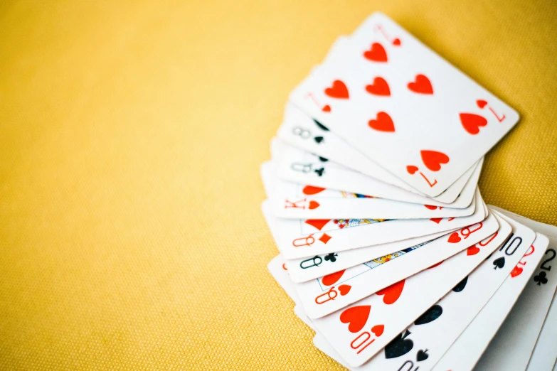 a pile of playing cards sitting on top of a table, unsplash, square, yellow and red, fan favorite, rectangle