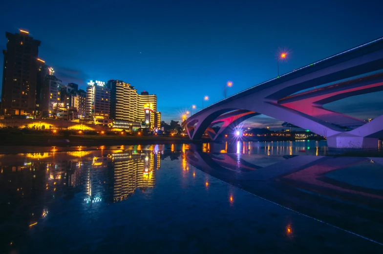 a bridge over a body of water at night, pexels contest winner, yeg, colorful city, early in the morning, neon reflections