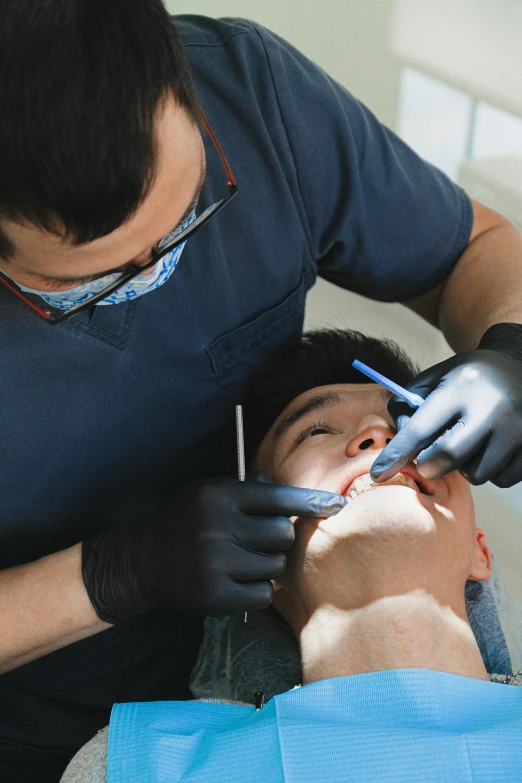 a man getting his teeth examined by a dentist, pexels contest winner, renaissance, square masculine jaw, asian male, head straight down, big gash on face