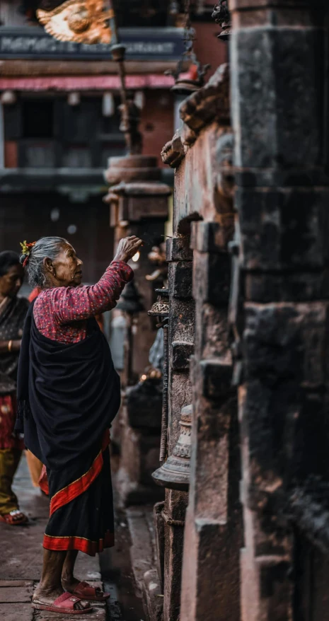 a group of people standing next to each other on a street, by Tobias Stimmer, pexels contest winner, hurufiyya, nepal, in an ancient altar, profile image, older woman