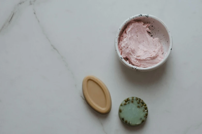 a bowl of ice cream next to a cookie, by Emma Andijewska, trending on pexels, art nouveau, a plaster on her cheek, minimal pink palette, soap carving, unfinished