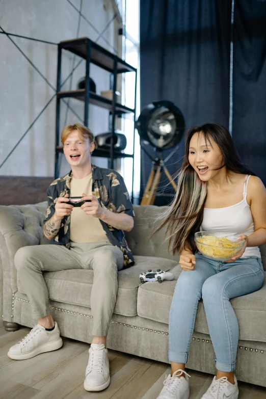 a couple of people that are sitting on a couch, a picture, video game, performing a music video, laughing, an asian woman