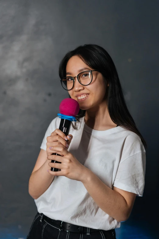 a woman in glasses is holding a microphone, inspired by Ruth Jên, pexels contest winner, happening, asian girl with long hair, standup comedian, portrait of tall, technical