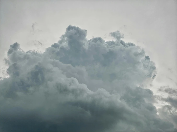 there is a plane that is flying in the sky, by Jan Rustem, unsplash, conceptual art, cumulus, close - up photograph, grey, voluminous