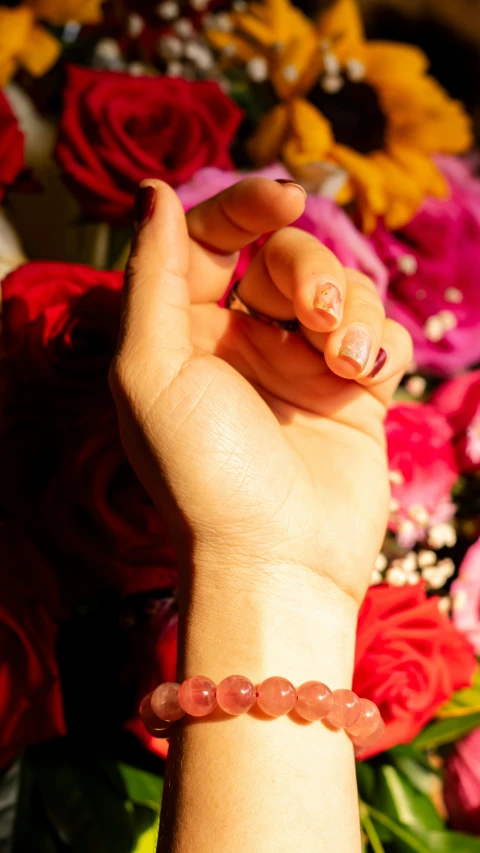 a close up of a person's hand near a bunch of flowers, profile image