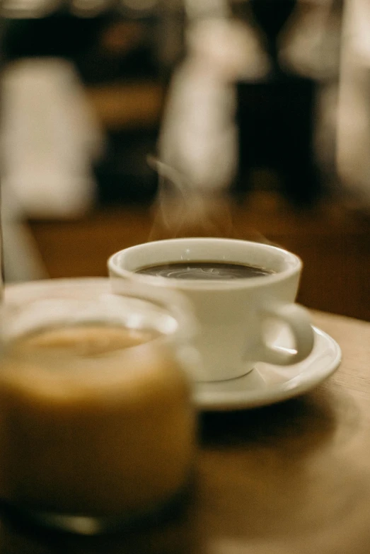 a cup of coffee sitting on top of a wooden table, profile image