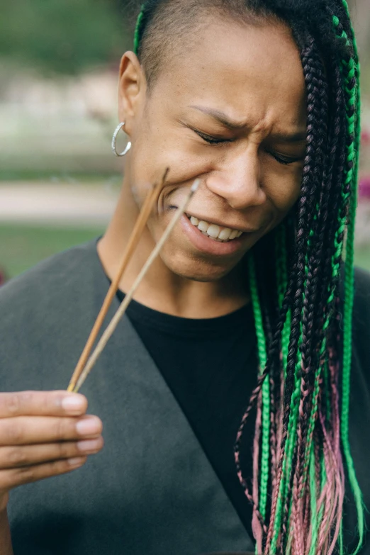 a woman with dreadlocks holding chopsticks in her hand, trending on pexels, renaissance, crying and puking, cornrows, with sprouting rainbow hair, disappointed