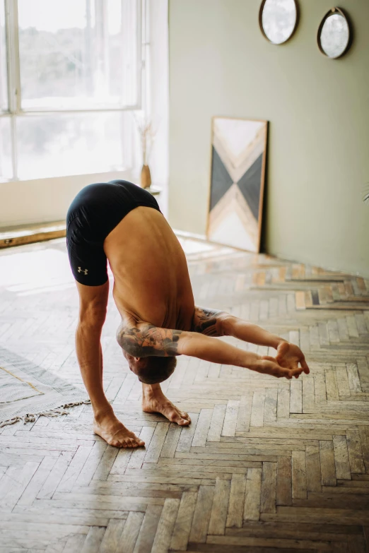 a man doing a handstand on a hard wood floor, unsplash, arched back, horned, sukhasana, profile image