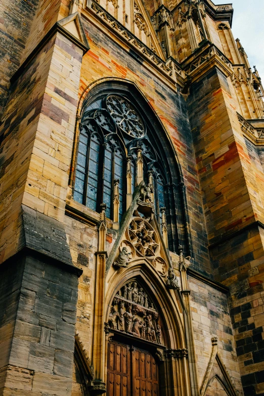 a tall building with a clock on top of it, dark gothic cathedral, ocher details, entrance, up-close