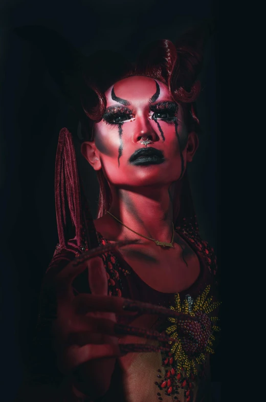 a woman that is standing in the dark, an album cover, inspired by Ignacy Witkiewicz, transgressive art, unreal engine : : rave makeup, drag queen, tribal red atmosphere, instagram post