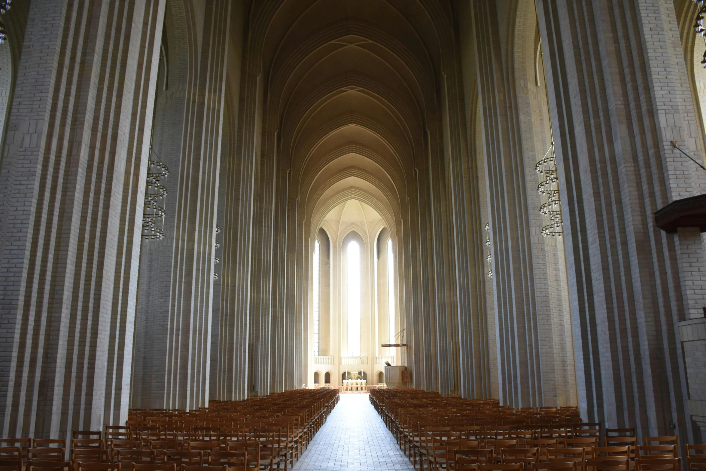 an empty church with rows of wooden chairs, a digital rendering, by Barthélemy d'Eyck, unsplash contest winner, romanesque, john pawson, view from front, hammershøi, gray
